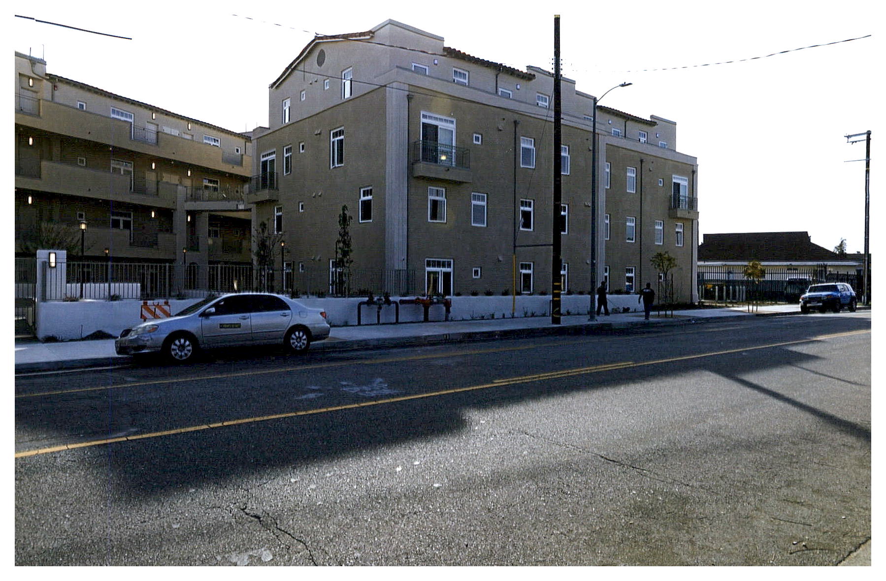 After: view of rear elevation showing four floor apartment building new construction on the site.
