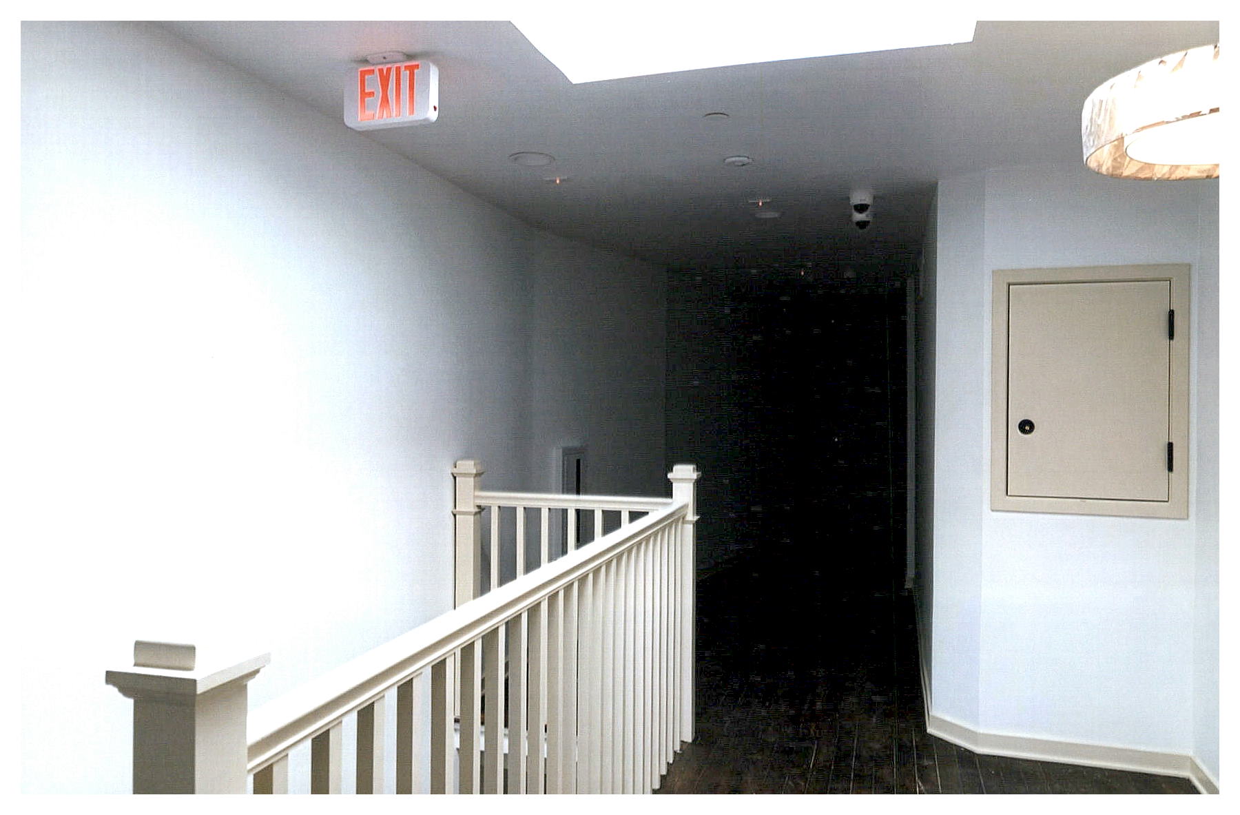 After: view of top floor hallway showing stair guard railing and skylight above stair.