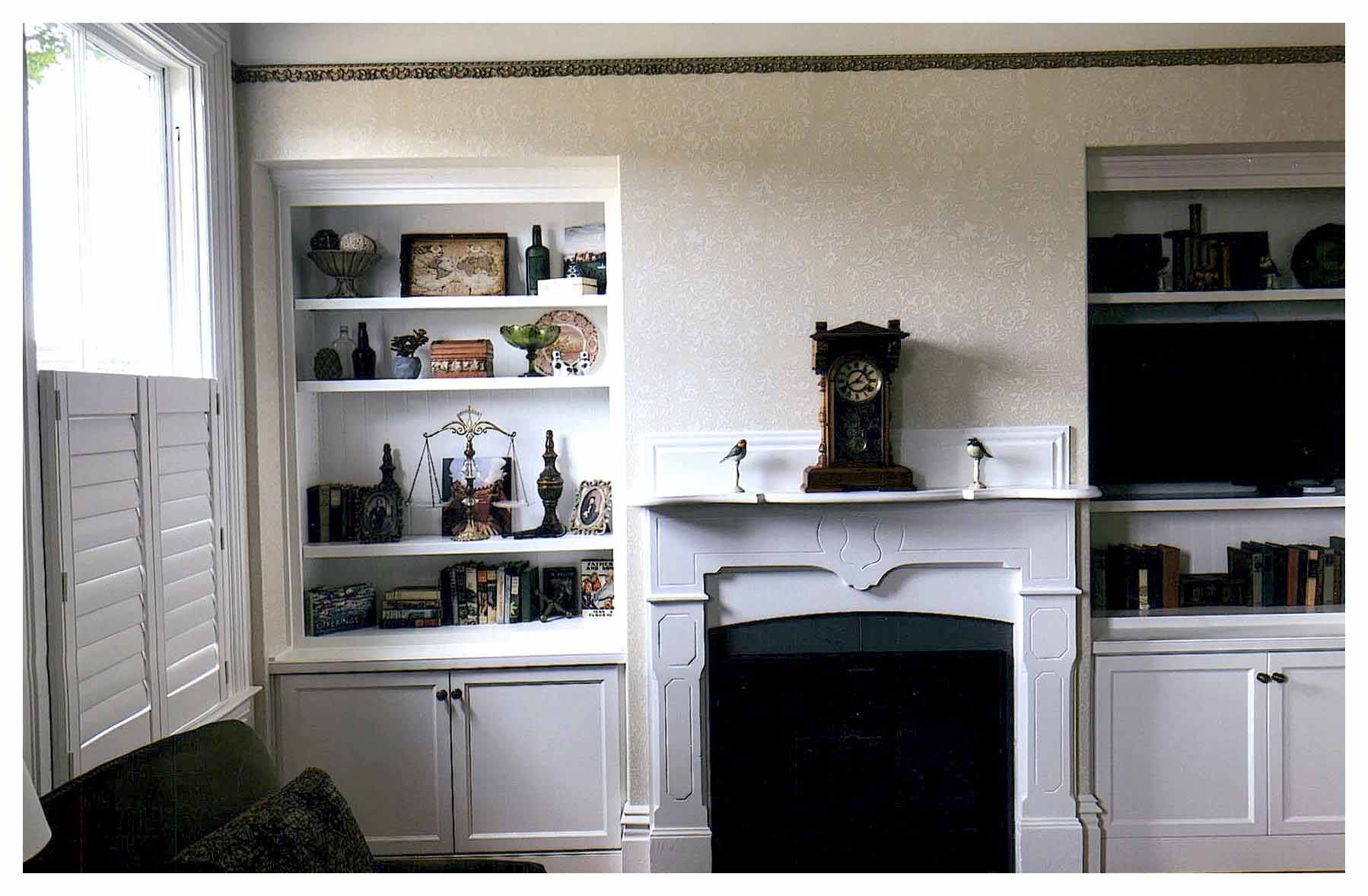 After: view of living area fireplace with new built-in shelving on either side.