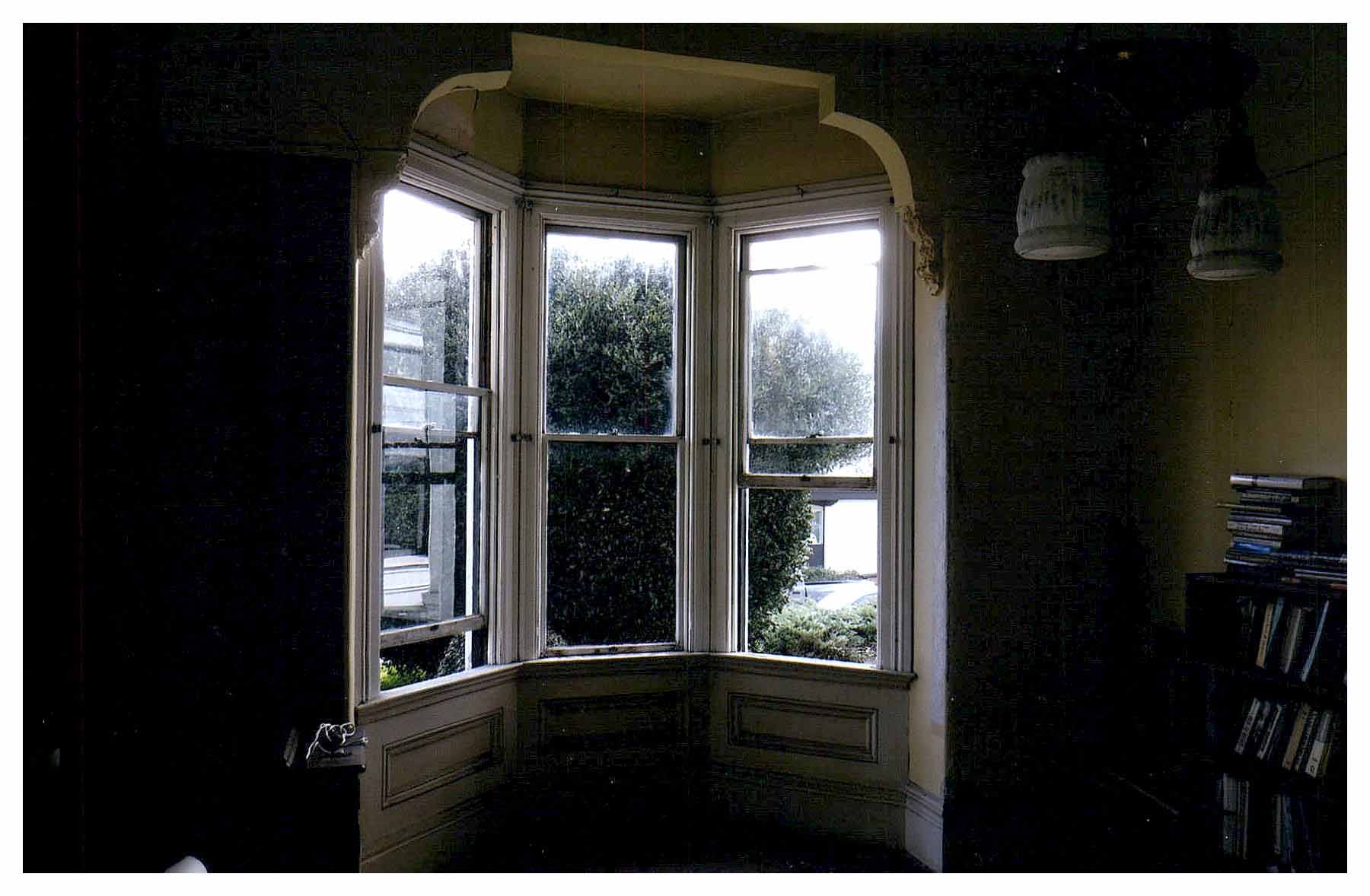 Before: same view of bay windows in alcove with the prior dark-colored walls.