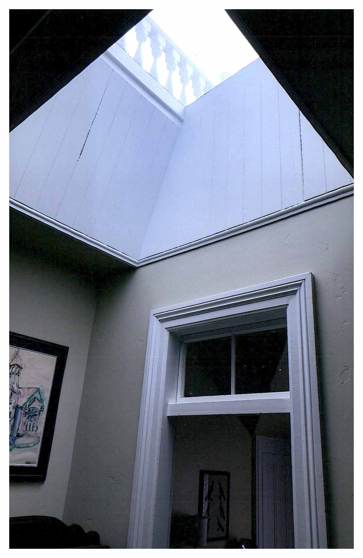 After: second floor hallway landing large skylight with a view of the restored ridge railing at the roof.