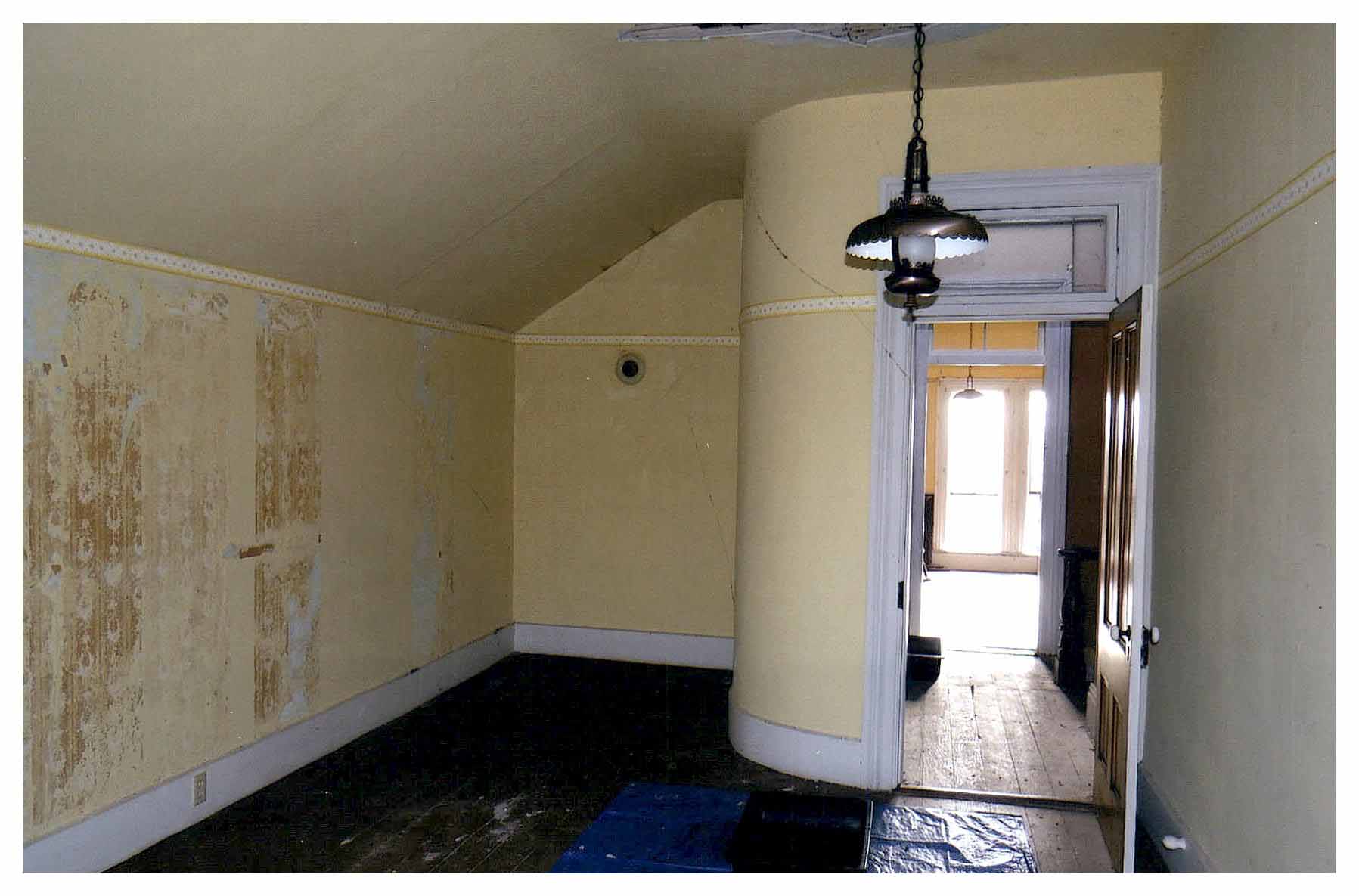 Before: same view of bedroom with unpainted faded light yellow walls.