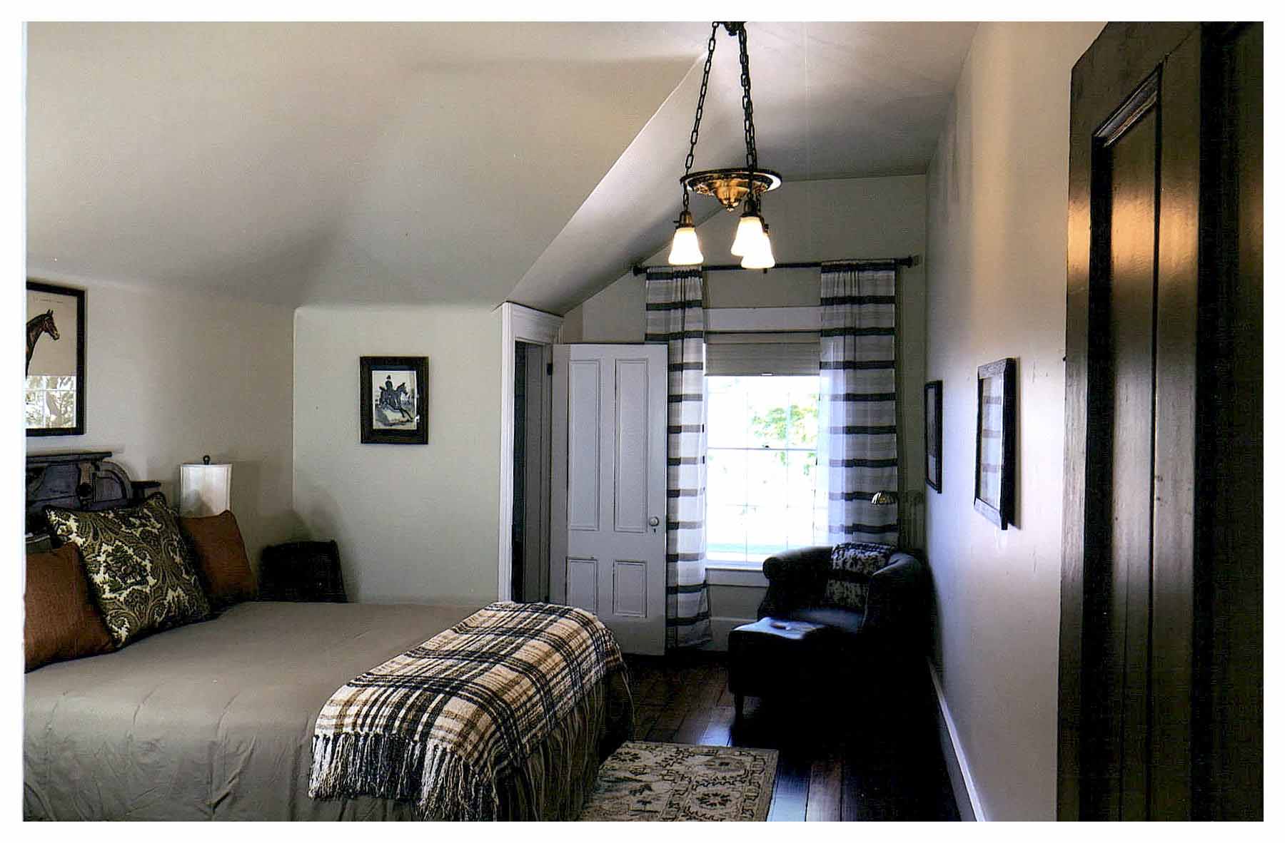 After: another bedroom with a sloped hipped ceiling at the corner closet. Walls are painted off-white.