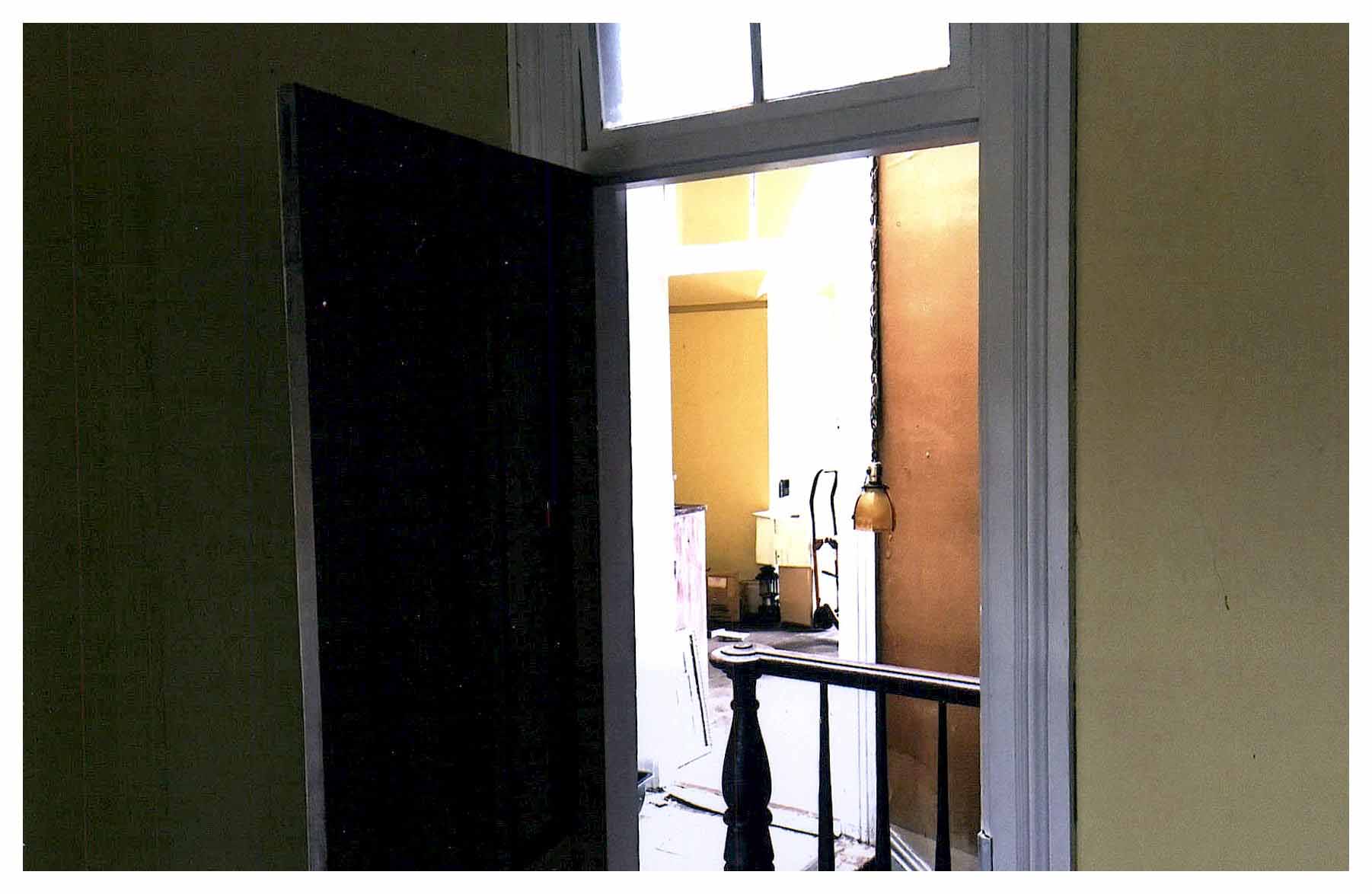 Before: same view looking through bedroom door with darker-colored surfaces and noticeably less light.