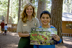 Junior Ranger with reward poster and park interpreter