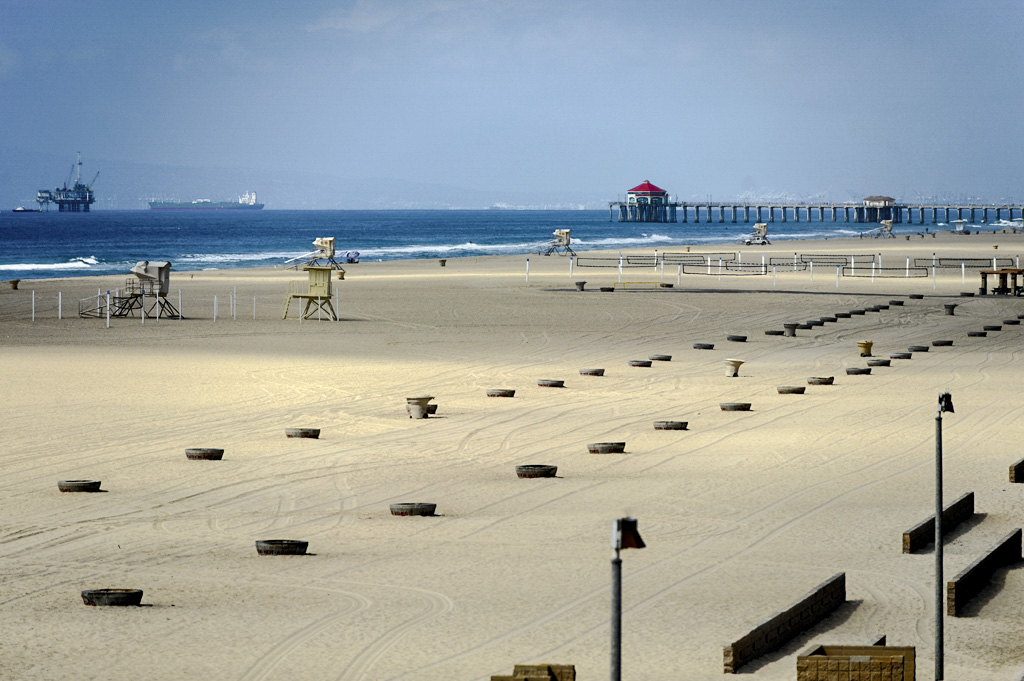 Aerial view of beach with bonfire rings, lifeguard towers, and the Huntington Beach Pier in the back