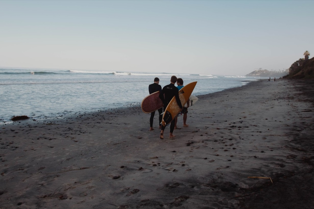 Photo of surfers walking along the beach at San Elijo State Beach